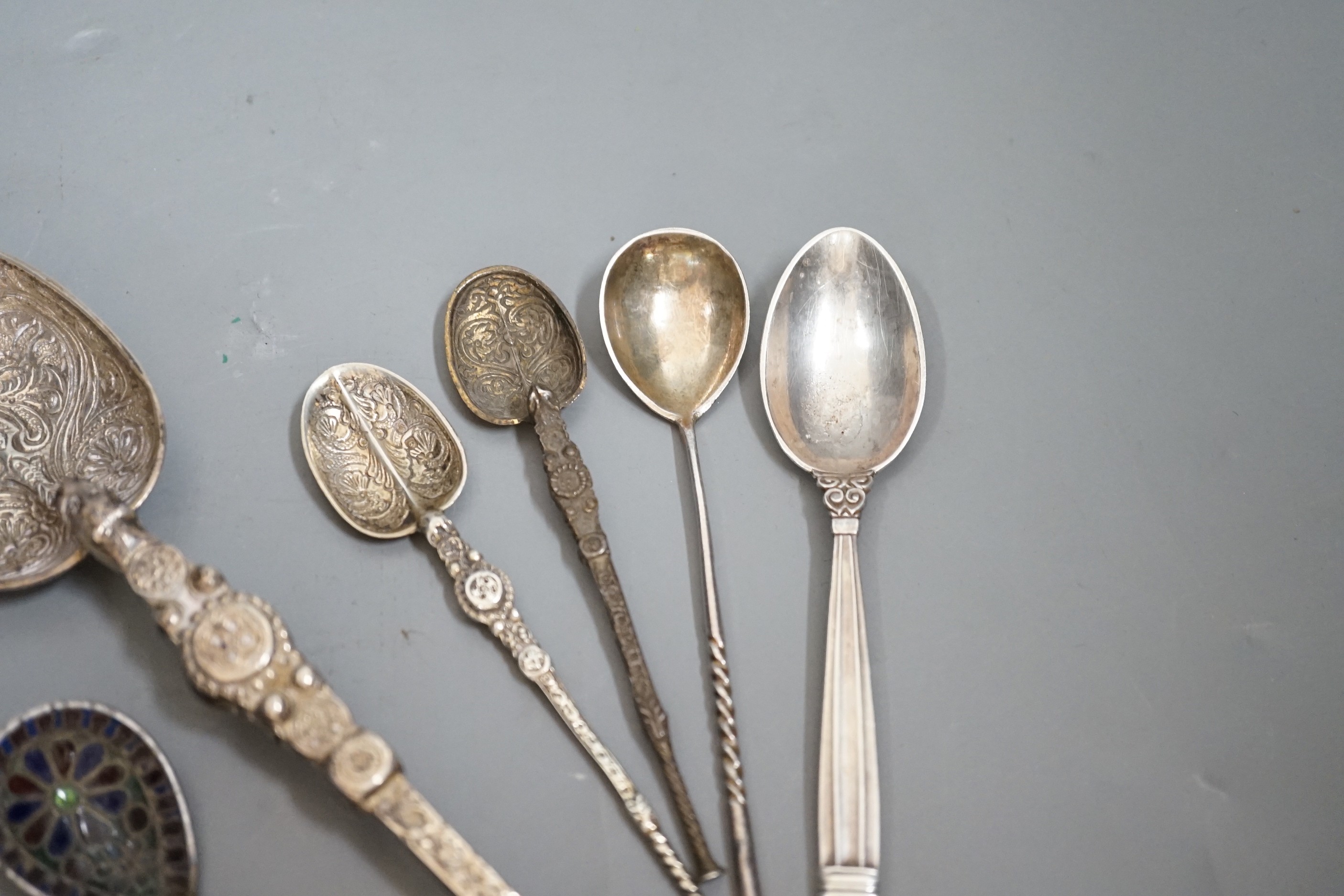 A 1930's silver replica of The Anointing spoon, 24.7cm, two similar smaller spoons, a Georg Jensen spoon, an Austro-Hungarian white metal and plique a jour spoon and a Russian tea spoon.